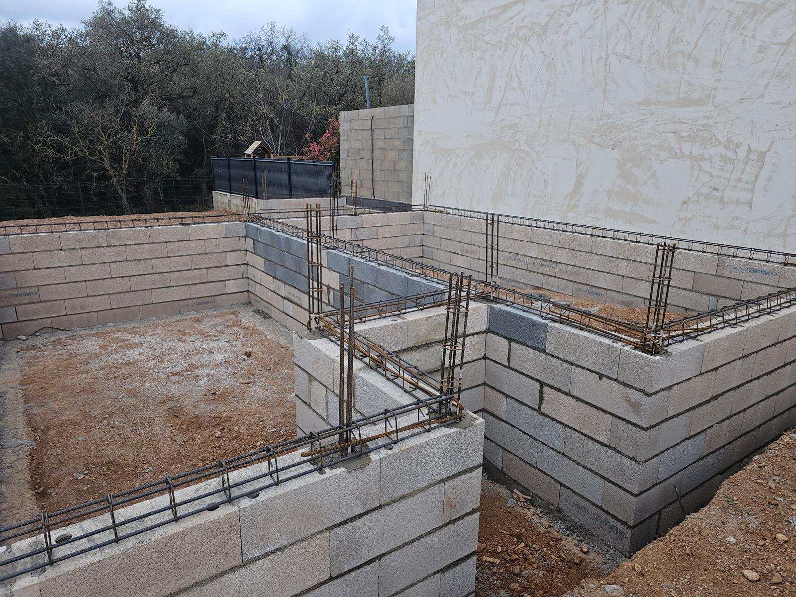 Démolition d’un mur de clôture puis réalisation d’une fondation et d’un mur de soutènement de 31ml sur 1,4m de hauteur dans l’attente de la suite des travaux