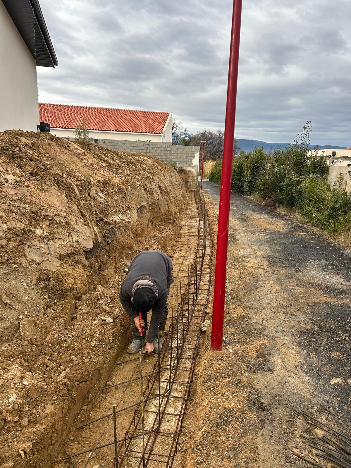 Démolition d’un mur de clôture puis réalisation d’une fondation et d’un mur de soutènement de 31ml sur 1,4m de hauteur dans l’attente de la suite des travaux