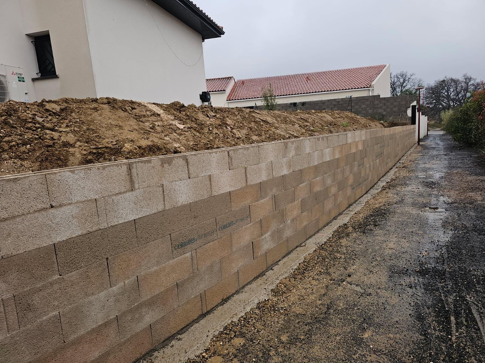 Démolition d’un mur de clôture puis réalisation d’une fondation et d’un mur de soutènement de 31ml sur 1,4m de hauteur dans l’attente de la suite des travaux