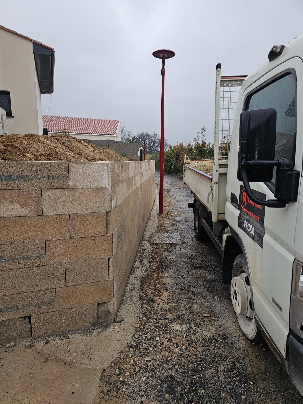 Démolition d’un mur de clôture puis réalisation d’une fondation et d’un mur de soutènement de 31ml sur 1,4m de hauteur dans l’attente de la suite des travaux